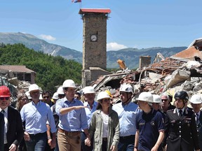 Canadian Prime Minister Justin Trudeau and his wife Sophie Gregoire-Trudeau are escorted by Italy Foreign Minister Angelino Alfano, second from the left, and officials during a visit at the earthquake-devastated village of Amatrice, on May 28.