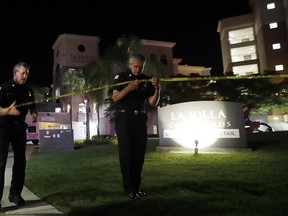 San Diego police officers work at a cordoned off La Jolla apartment after a shooting Sunday, April 30, 2017, in San Diego.