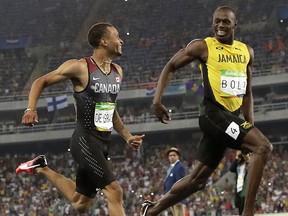 Canada's Andre De Grasse, left, and Jamaica's Usain Bolt smile at each other in a men's 200-meter semifinal, during the athletics competitions of the 2016 Summer Olympics at the Olympic stadium in Rio de Janeiro, Brazil, Wednesday, Aug. 17, 2016.