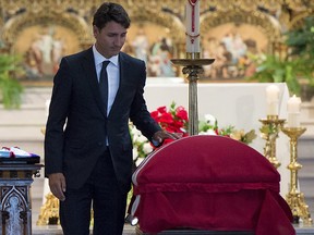 Prime Minister Justin Trudeau touches the casket of MP Mauril Belanger after delivering a eulogy during his funeral at the Notre-Dame Cathedral Basilica, on Saturday, Aug. 27, 2016 in Ottawa.