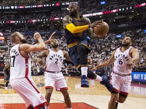 Cleveland Cavaliers’ LeBron James drives to the basket between the Raptors’ Jonas Valanciunas, PJ Tucker and Cory Joseph during the first half of Game 3 of their Eastern Conference semifinal series at the Air Canada Centre in Toronto on Friday night.