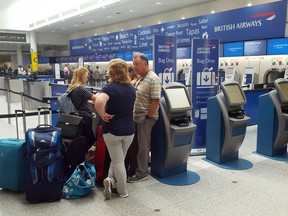 Passengers stand at the British Airways check-in desk after the airport suffered an IT systems failure, at London''s Gatwick Airport, Saturday, May 27, 2017. British Airways canceled all flights from London's Heathrow and Gatwick airports Saturday as a global IT failure caused severe disruption for travellers on a busy holiday weekend.
