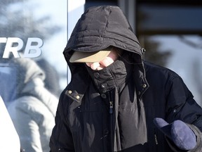 Martina Cain covers her face as she leaves the Saskatchewan Professional Teachers Regulatory Board office in Regina