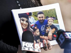 Julie Campos, wife of Luis Campos, holds a family photo during a news conference in Las Vegas.