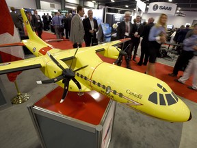 Delegates pass a model of the Airbus C-295 fixed-wing search and rescue aircraft at the Canadian Association of Defence and Security Industries' trade show in Ottawa.
