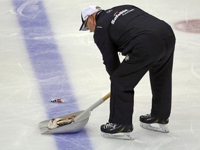 An ice worker removes a fish during the second period of Game 1 of the NHL hockey Stanley Cup Finals between the Pittsburgh Penguins and Nashville Predators on Monday, May 29, 2017, at PPG Paints Arena in Pittsburgh.