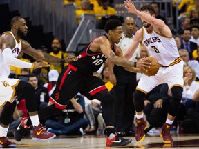 DeMar DeRozan of the Toronto Raptors is being double teamed by Cleveland Cavaliers' LeBron James, left, and Kevin Love during Game 1 action in their Eastern Conference semifinal Monday in Cleveland. With James scoring 35 points, the Cavs were 116-105 winners.