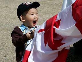 2 year old William Yang gets wrapped up in a Canadian flag.