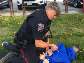 A Hamilton police officer arrests Global News journalist Jeremy Cohn at the scene of a fatal accident on Tuesday.