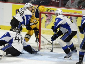 Taylor Raddysh, left, of the Erie Otters, is able to get his stick on a loose puck to get it past Saint John Sea Dogs' goaltender Callum Booth during semifinal action at the Memorial Cup tournament in Windsor on Friday. Trying to knock Raddysh off the puck is defenceman Chase Stewart. The Otters won 6-3 to advance to the tournament final against host Windsor on Sunday night.