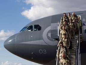 Soldiers disembark from their plane as they return home from Afghanistan at the Edmonton International Airport in Edmonton, Alta. on Friday, Oct. 11, 2013