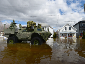 Canadian soldiers drive along a flooded street in Gatineau, Quebec, on Wednesday, May 10, 2017.