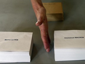 A worker places the ballots on a table at a polling station at the town hall of Bayonne, southwestern France, Friday, May 5, 2017. France will vote on Sunday May 7 in the second round of the presidential election.