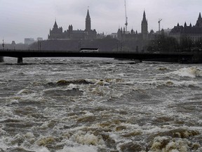 Parliament Hill is seen in the background as the Ottawa River runs high against the Portage Bridge after passing through the Chaudiere Falls in Ottawa on Saturday, May 6, 2017.