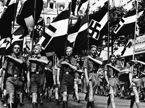 In this Feb. 24, 1936 file photo a group of boys march beneath Nazi standards in Berlin. Anti-Semitic propaganda had a life-long effect on German children schooled during the Nazi period, leaving them far more likely to hold racist ideas than those born earlier and later, according to a study published Monday, June 15, 2015.