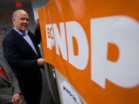 NDP Leader John Horgan stops to talk with a volunteer during a campaign stop at local candidate Bowinn Ma's campaign office in North Vancouver, B.C., on Wednesday May 3, 2017. A provincial election will be held on Tuesday. THE CANADIAN PRESS/Darryl Dyck