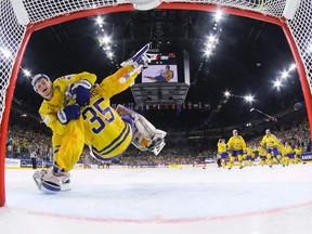 Swedish forward William Nylander (front) celebrates with goalie Henrik Lundqvist after beating Canada for gold in a shootout on May 21.