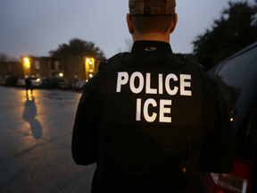 U.S. Immigration and Customs Enforcement agents enter an apartment complex looking for a specific undocumented immigrant convicted of a felony during an early morning operation in Dallas on March 6, 2015.