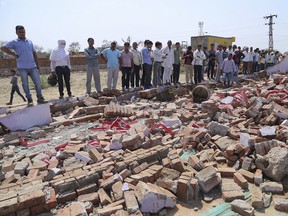 People look at the debris after a building wall collapsed onto guests at a wedding in Bharatpur district, Rajasthan state nearly 200 kilometers (125 miles) south of New Delhi, India, Thursday, May 11, 2017.