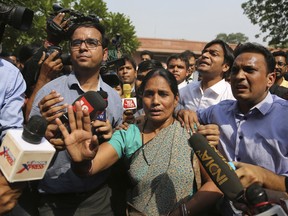Journalists crowd around Asha Devi, mother of the victim of the fatal 2012 gang rape on a moving bus, after the Supreme Court verdict in the case, in New Delhi, India, Friday, May 5, 2017