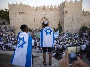 Israelis carry national flags outside the Old City's Damascus Gate in Jerusalem Wednesday, May 24, 2017, during Jerusalem Day which marks the 50th anniversary of Israel's capture of the city's eastern half from Jordanian control during the Six-Day War in 1967.