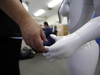 An employee touches the hand of Pepper the humanoid robot, manufactured by SoftBank Group Corp., at the Orange Arch Inc. offices in Tokyo, Japan, on Monday, Oct. 5, 2015.