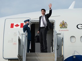 Prime Minister Justin Trudeau waves from he stairs of his plane as he departs Ottawa on Wednesday, May 24, 2017, on route to Europe.