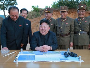 This picture taken on May 14, 2017 and released from North Korea's official Korean Central News Agency (KCNA) on May 15 shows North Korean leader Kim Jong-Un (C) reacting during a test launch of a ground-to-ground medium long-range strategic ballistic rocket Hwasong-12 at an undisclosed location.