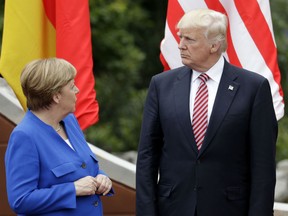 German Chancellor Angela Merkel, left, speaks with U.S. President Donald Trump during a group photo at the G7 Summit on May 26, 2017.