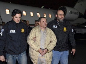 In this Jan. 19, 2017 file photo authorities escort Joaquin "El Chapo" Guzman from a plane to a waiting caravan of SUVs at Long Island MacArthur Airport, in Ronkonkoma, N.Y.