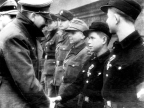 Adolf Hitler, left, shakes hands with 12-year-old Alfred Czech, a Hitler Youth soldier, after the young veteran of battles in Pomerania and Upper and Lower Silesia was awarded the Iron Cross at Hitler's headquarters in Germany on March 19, 1945, according to the German caption that accompanied the photo, taken by a Nazi photographer.