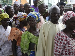 Parents of the kidnapped schoolgirls wait to be transported to they venue where they will be reunited with their daughters, in Abuja, Nigeria, Saturday, May 20, 2016. Officials say the 82 Nigerian schoolgirls recently released after more than three years in Boko Haram captivity are reuniting with their families for the first time.