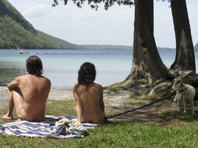Michael Zarnowski, left, and Katelyn Comeau, of Thornton, N.H., relax at the clothing-optional beach known as the Southwest Cove of Lake Willoughby in Westmore, Vermont.
