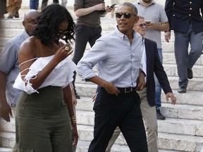 U.S. former President Barack Obama and his wife Michelle walk during their visit to Siena, Tuscany region, Italy.