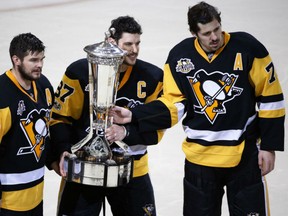 From left, Chris Kunitz, Sidney Crosby and Evgeni Malkin hold up the Prince of Wales Conference Trophy after beating the Ottawa Senators 3-2 in double overtime in Game 7 on May 25.