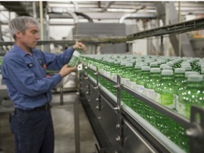 Ben Jensen, Maintenance Supervisor at Ice River Springs, examines one of many bottles of Ice River Green water at the Ice River Springs bottling facility in Feversham, Ontario.