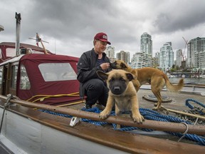 Shawn Wilson, along with his dogs Sage and her 1 month old puppy Kuma, live on his boat in False Creek in Vancouver, B.C., May 1, 2017