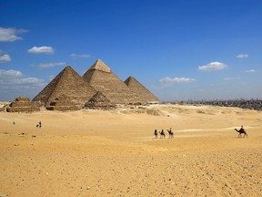 Tourists ride camels at the site of the Giza Pyramids near Cairo, Egypt.