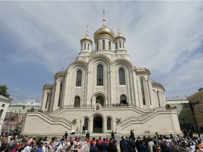 People gather outside the Temple of the Resurrection of Christ and the New Martyrs and Confessors of the Russian Orthodox Church, which has been accused of corruption in the past.