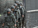 South Korean Army soldiers patrol along a barbed-wire fence in Paju, South Korea, on April 13, 2013.