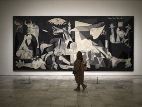 A woman looks at Picasso's famous Guernica painting, depicting the bombing of the village during the Spanish Civil War