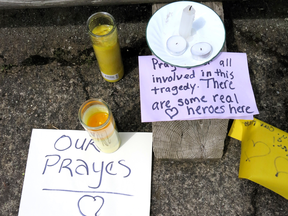 Messages of support and candles for an injured employee are shown outside a grocery store in Estacada, Ore., Monday, May 15, 2017.