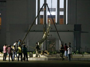 Bangladeshi workers take down a controversial statue on the premises of the country's highest court after Islamist radicals protested for months against what they called an "un-Islamic" Greek deity on May 26, 2017.