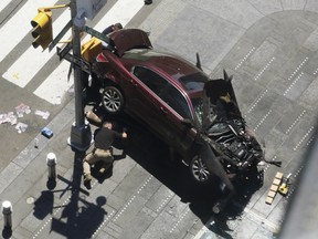 A police officer inspects a car crash, Thursday, May 18, 2017, in New York's Times Squar