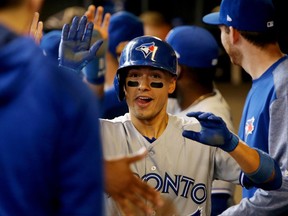 Ryan Goins celebrates his grand slam against the Milwaukee Brewers with Toronto Blue Jays teammates on May 24.