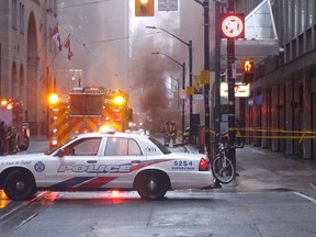 Police are clearing a busy intersection in downtown Toronto as smoke pours from a grate and loud blasts are heard on Monday, May 1, 2017. An officer at the scene was telling people to move away from the area, near King and Yonge street.