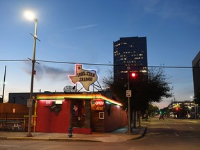 In Houston, day gives way to evening and the neon of the Lone Star Saloon.