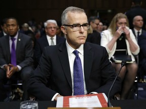 Acting FBI Director Andrew McCabe sits with a folder marked "Secret" in front of him while testifying on Capitol Hill in Washington.