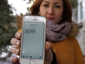 In this photo taken Wednesday, Feb. 22, 2017, television journalist Julia Kirienko holds up her smartphone to show a text message reading ìUkrainian soldiers, theyíll find your bodies when the snow meltsî, in Kiev, Ukraine.