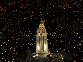 The statue of the Virgin Mary is carried by believers to the church of the Fatima shrine for the night mass on May 12, 2009